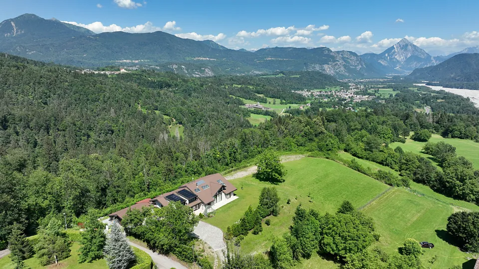 The house on the hill between woods and meadow, with the valley and mountains behind