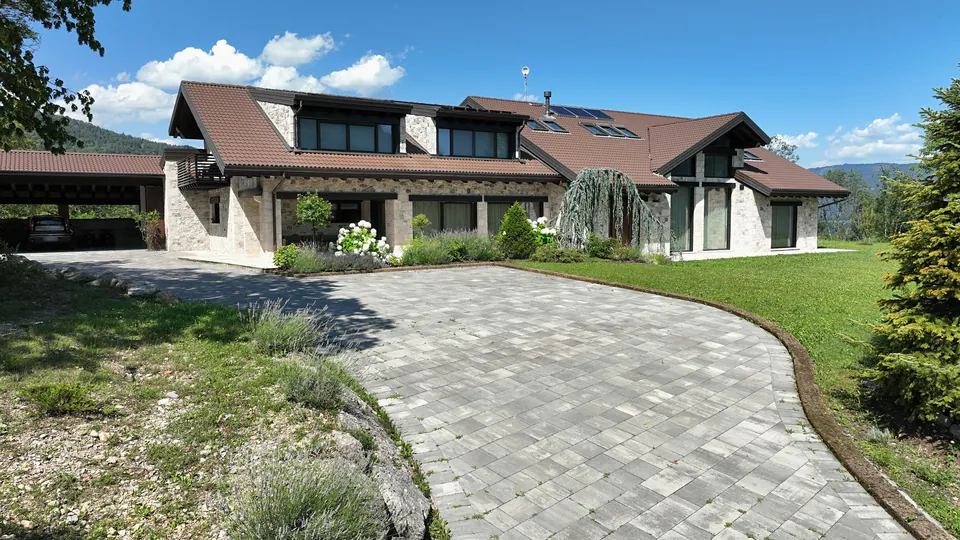 Arrival at the house: paved yard, carport and stone facade
