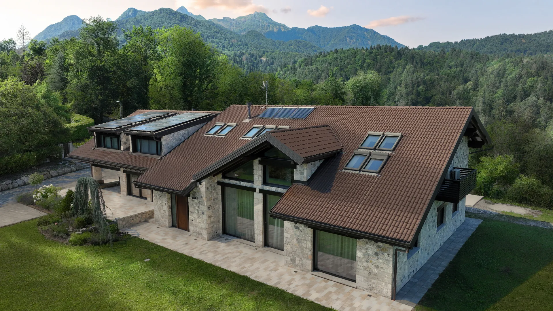 Simulation: the stone house seen from a drone with warm light and an evening sky